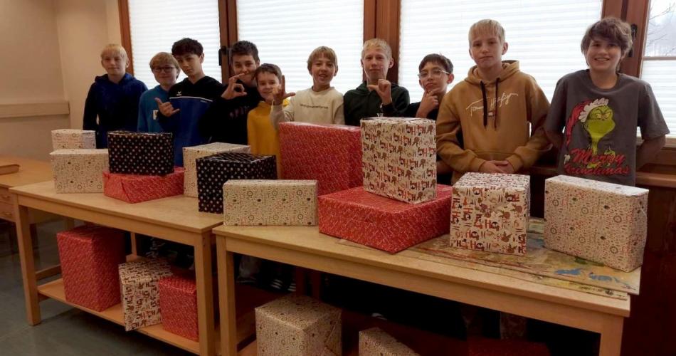 10 Jungs vor ihren verpackten Geschenken