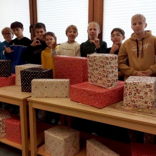 10 Jungs vor ihren verpackten Geschenken